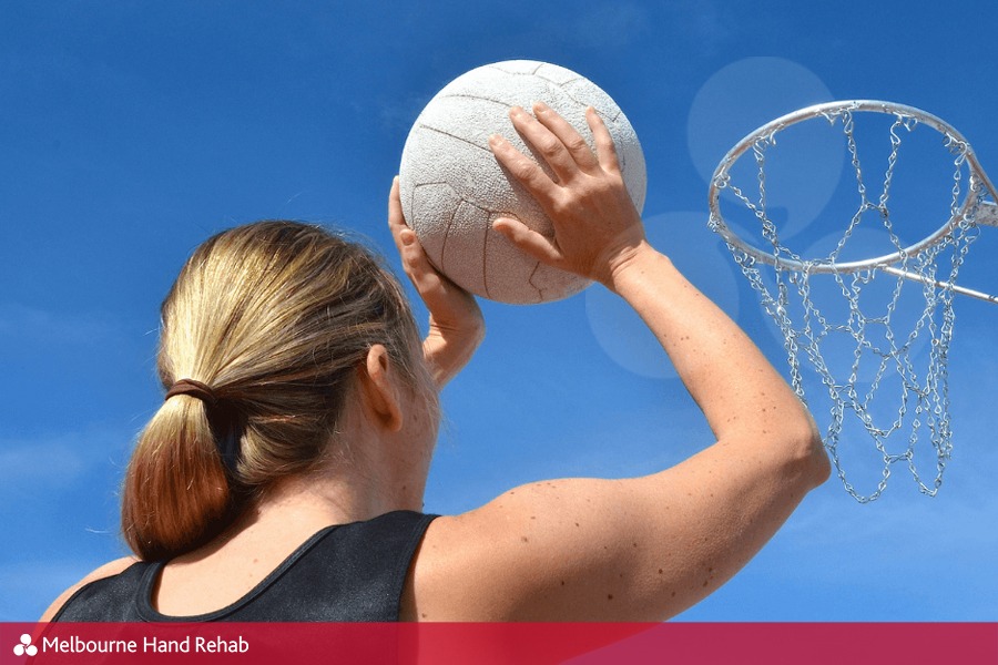 Female netball player shooting a goal