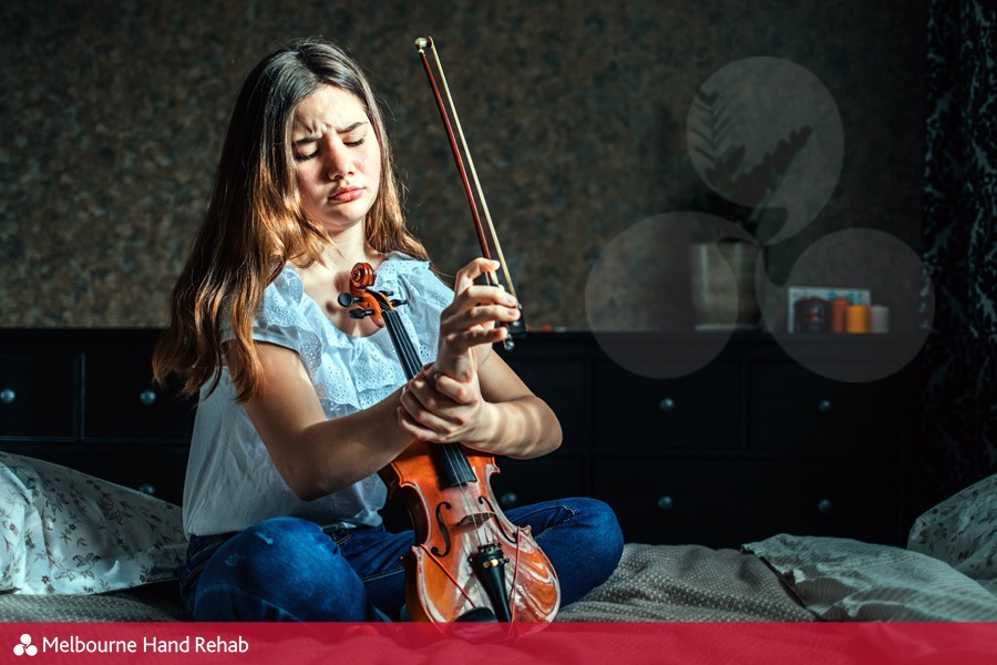 Young violin player with a sore wrist