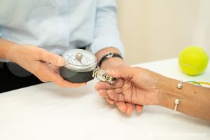 Melbourne Hand Rehab hand therapist tests a patients strength using a grip gauge