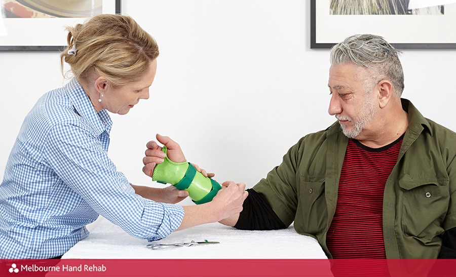 Melbourne Hand Rehab hand therapist Karen Fitt fitting a new hand splint onto male patient