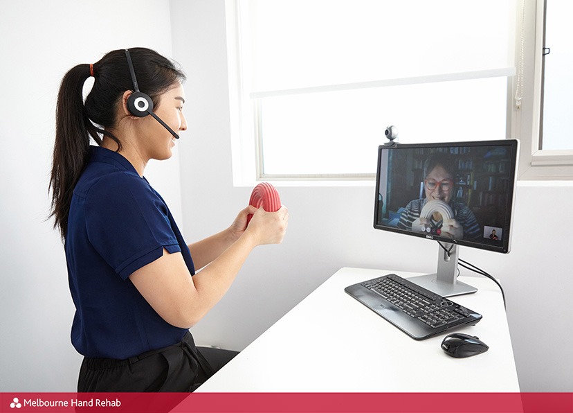 A Melbourne Hand Rehab hand therapist demonstrates an exercise during a telehealth online video consultation