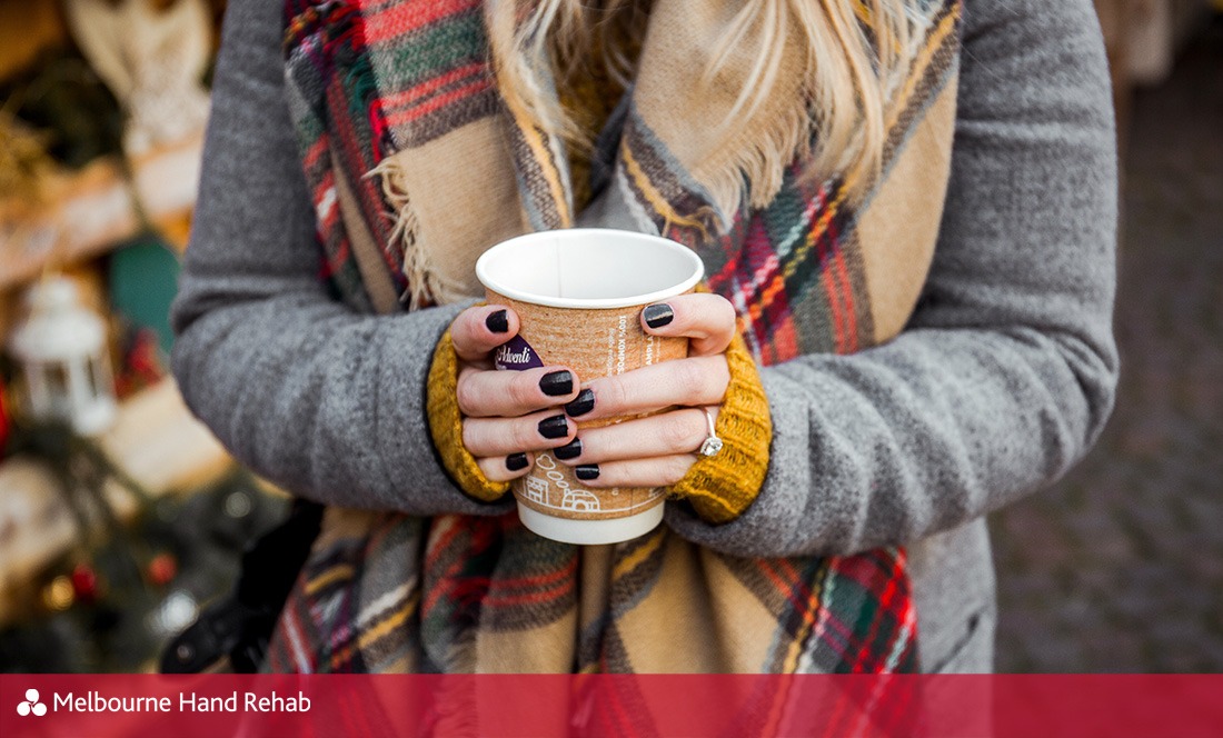 Cold hands holding a cup of takeaway coffee