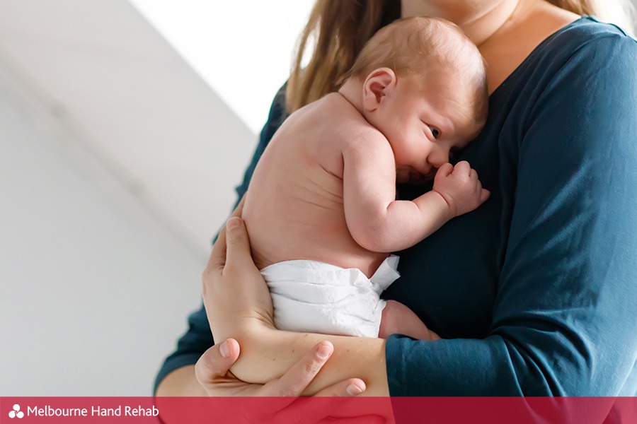 Mother holding a baby. Many pregnant women suffer from Carpal Tunnel Syndrome.