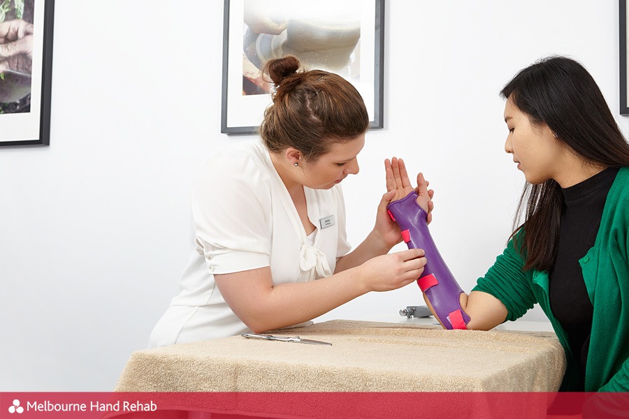 Melbourne Hand Rehab hand therapist adjusting a custom splint that has been made for a patient