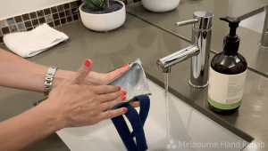 Patient washing a custom made splint by Melbourne Hand Rehab
