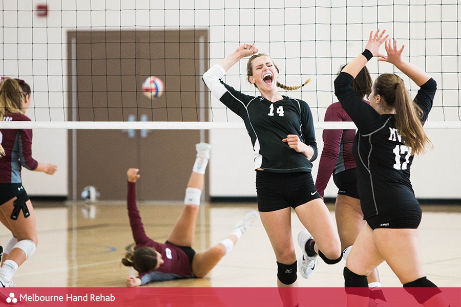 Female volleyball players cheering after a point win