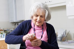 Women with arthritis struggling to open a jar