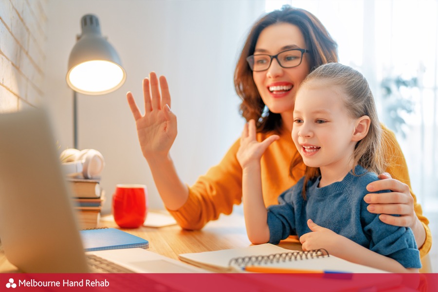 Mother and child using hand therapy telehealth service