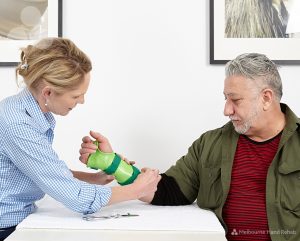 Man wearing a custom made green wrist splint at Melbourne Hand Rehab