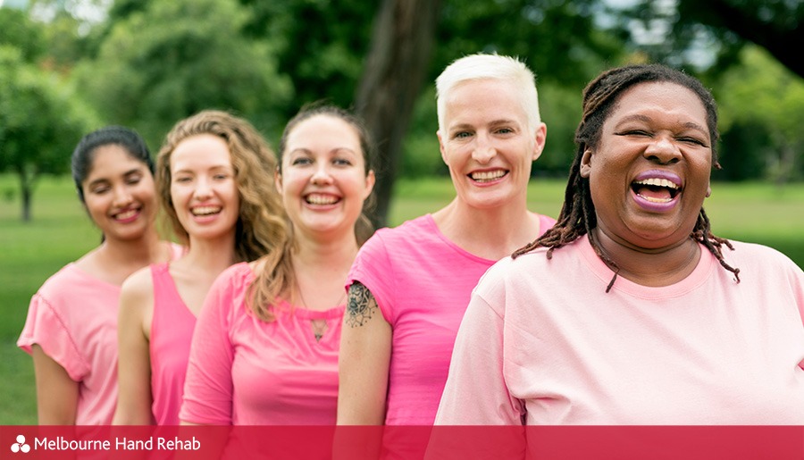 Diverse group of women wearing pink shirts in recognition of October being Breast Cancer Awareness Month