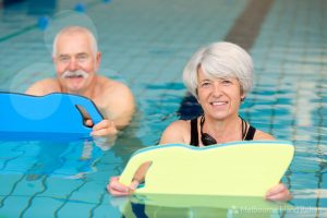 Older man and woman participating in a hand therapy hydrotherapy class