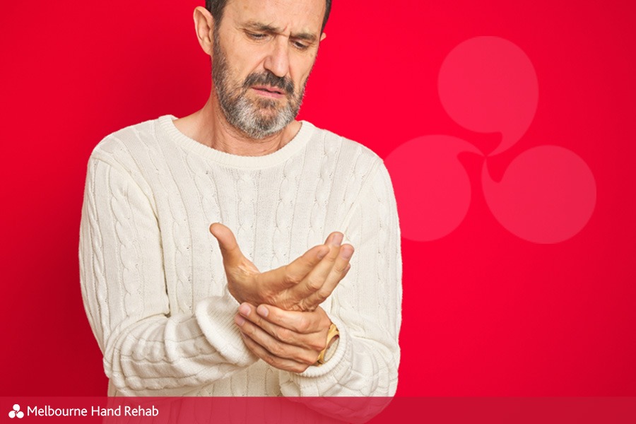 Image of man on a red background with a painful hand (Chronic Regional Pain Syndrome CRPS)
