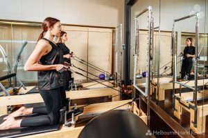 Pilates and hand therapy. Melbourne Hand Rehab client using a pilates reformer as part of there hand therapy treatment.