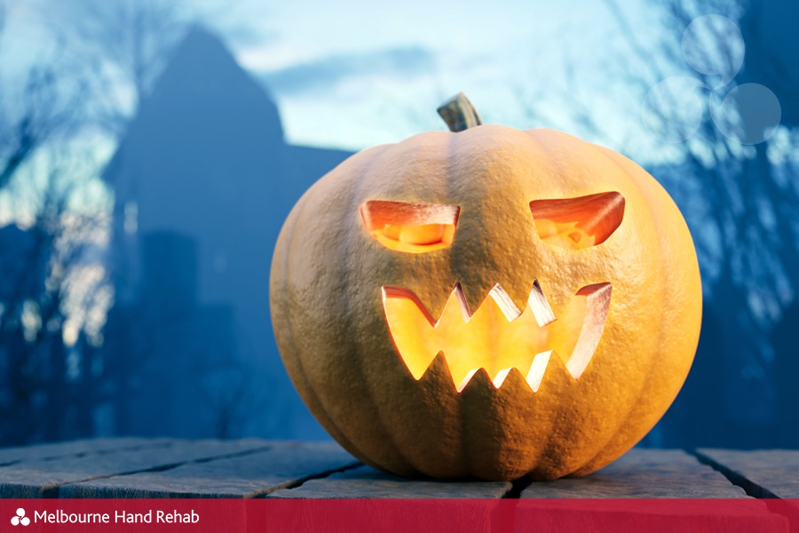 Halloween pumpkin glowing on gothic graveyard. Jack-o'-lantern scary carved face. Staying Safe While Carving Your Halloween Pumpkin.